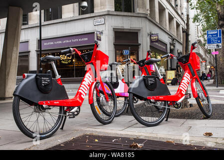 Londres, UK - Août 2019 : Dockless rouge saut vélo électrique exploité par Uber dans une rue dans le centre de Londres. Banque D'Images