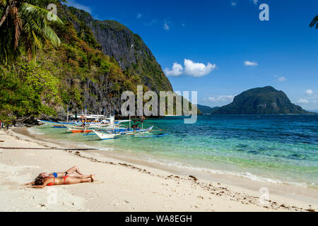 Les femmes qui le bronzage sur Pasandigan Beach, El Nido, Palawan, Philippines Banque D'Images