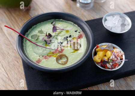 Soupe aux légumes d'été froid glace aux épices et mangold, feuille et de mangue au crabe servi en saucière Banque D'Images