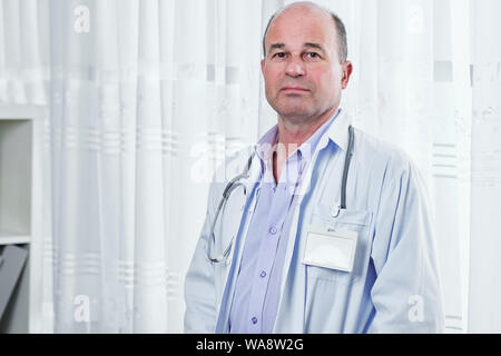 Portrait du docteur en grave triste labcoat blanc avec badge vide looking at camera Banque D'Images