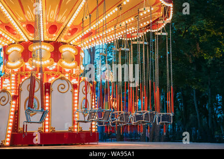 Éclairées Free carousel Merry-Go-Round. Soirée d'été dans le parc d'attractions de la ville. Banque D'Images