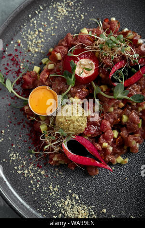 Tartare de boeuf d'oeuf sur une surface grise, vue de dessus, close-up copy space Banque D'Images