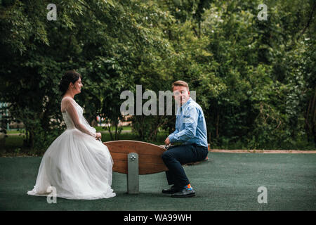 Jeunes mariés aiment passer du temps sur les balançoires. Mariage Concept, des jeunes mariés, nouvelle famille, copie de l'espace. Banque D'Images