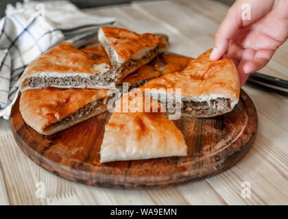 Ossètes traditionnels pâtés à la viande de boeuf avec une femme part Banque D'Images