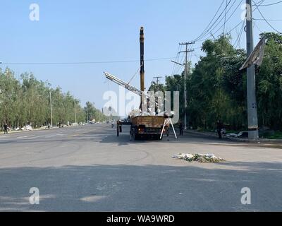 Les travailleurs chinois à déloger les débris d'arbres et poteaux télégraphiques brisée par des vents violents causés par une tornade dans la ville de Kaiyuan, Tieling city, au nord-est Banque D'Images