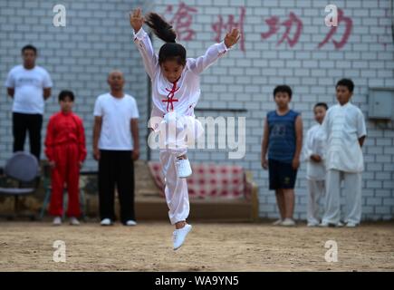 Un enfant chinois arts martiaux chinois pratiques ou kungfu réalisé par Chen Honglin, un praticien local bien connu, de maintenir la somme au cours de remise en forme Banque D'Images