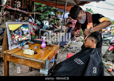 Bac Ha, Vietnam - 26 août : la coupe de cheveux coiffure non identifiés pour client au marché le dimanche 26 août 2018 à Bac Ha, au Vietnam. Banque D'Images