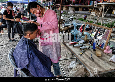 Bac Ha, Vietnam - 26 août : la coupe de cheveux coiffure non identifiés pour client au marché le dimanche 26 août 2018 à Bac Ha, au Vietnam. Banque D'Images