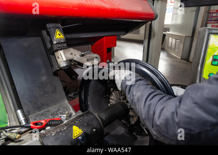 Le processus de réparation d'une automobile à l'aide d'une presse spéciale sur une machine pour le redressage des disques pour véhicules après dommages dans une fosse sur la route Banque D'Images