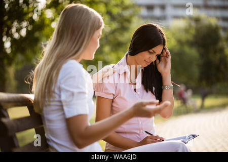Femme est consolant son amie dans le parc. Banque D'Images