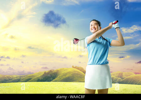 Femme Asiatique le bois swing club de golf sur le green de golf Banque D'Images