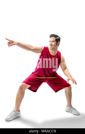 Joueur de basket-ball homme asiatique dans la pose de dribbler le ballon isolated over white background Banque D'Images