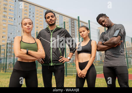 Les jeunes hommes et femmes en sport activewear debout dans l'environnement urbain Banque D'Images