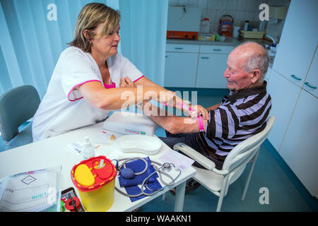 Hohen Wangelin, Allemagne. 25 Juin, 2019. Veronica infirmière Timm prend des échantillons de sang de Günter Ludwig patient dans une salle de consultation dans la pratique de la 74-year-old country médecin Lothar Kruse. Le médecin généraliste a été le traitement des patients de la région dans son cabinet à Hohen Wangelin pendant 40 ans. À la fin de 2019, Kruse veut renoncer à sa pratique, mais n'a jusqu'à présent tenté d'obtenir un successeur. Credit : Jens Büttner/dpa-Zentralbild/ZB/dpa/Alamy Live News Banque D'Images