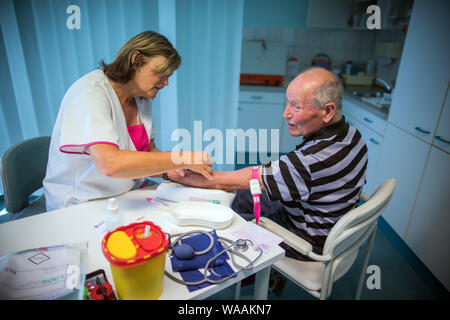 Hohen Wangelin, Allemagne. 25 Juin, 2019. Veronica infirmière Timm prend des échantillons de sang de Günter Ludwig patient dans une salle de consultation dans la pratique de la 74-year-old country médecin Lothar Kruse. Le médecin généraliste a été le traitement des patients de la région dans son cabinet à Hohen Wangelin pendant 40 ans. À la fin de 2019, Kruse veut renoncer à sa pratique, mais n'a jusqu'à présent tenté d'obtenir un successeur. Credit : Jens Büttner/dpa-Zentralbild/ZB/dpa/Alamy Live News Banque D'Images