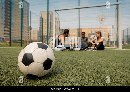Ballon de soccer se trouvant sur le terrain de jeux ou de joueurs en arrière-plan Banque D'Images
