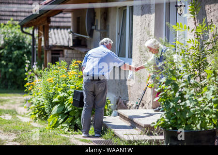 Neu Gaarz, Allemagne. 25 Juin, 2019. Le 74-year-old country médecin Lothar Kruse est accueilli à son domicile par les 89 ans, Irmgard Brockmann à la porte de sa cour. Le médecin généraliste a été le traitement des patients de la région dans son cabinet à Hohen Wangelin pendant 40 ans. À la fin de 2019, Kruse veut renoncer à sa pratique, mais n'a jusqu'à présent tenté d'obtenir un successeur. Credit : Jens Büttner/dpa-Zentralbild/ZB/dpa/Alamy Live News Banque D'Images