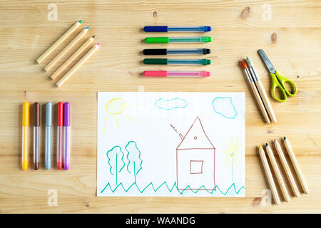 Crayons, stylos, ciseaux et pinceaux entourant kid dessin de chambre Banque D'Images