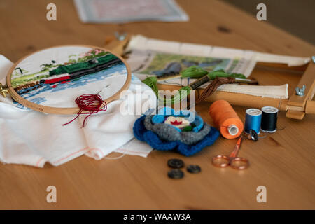 Broderie au point de croix, matériaux, y compris les fils, aiguilles, ciseaux, , et cerceaux. disposés sur une table pour l'artisanat/hobby Banque D'Images