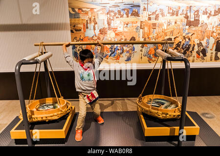 Le Japon, Honshu, Tokyo, Tokyo Metropolitan Marunouchi, musée Edo-Tokyo, posant avec un jeune visiteur portant des paniers traditionnels, 30076394 Banque D'Images