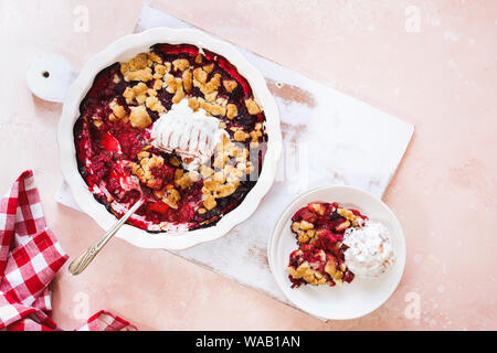 Crumble de fruits d'été dans le plat de cuisson et d'une partie sur la plaque. Vue de dessus, l'espace vide Banque D'Images