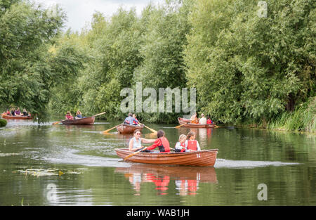 Les visiteurs au moulin de Flatford voitures bateaux à rames pour explorer la rivière Stour, Dedham Vale, Suffolk, Angleterre, RU Banque D'Images