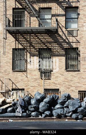 New York - des sacs à ordures ménagères en attente de collecte sur un trottoir de Manhattan. Banque D'Images