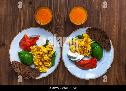 Oeufs brouillés au saumon fumé, sur des toasts au levain. Banque D'Images
