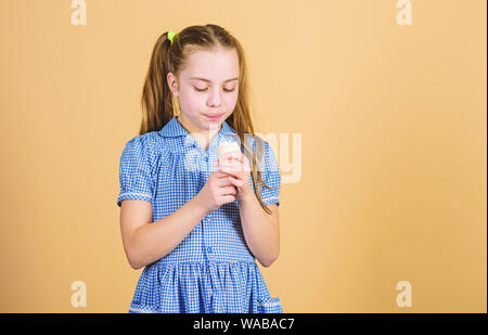 Plus de saveur plus amusant. Petit enfant de lécher la crème glacée à saveur naturelle. Cute little girl apprécier la saveur et arôme de desserts congelés. Kid adorable saveur crème dessert manger additif, copiez l'espace. Banque D'Images