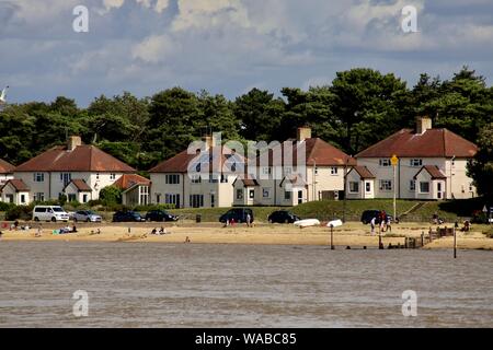 UK - Felixstowe Ferry, Suffolk - 19 août 2019 : lumineux, ensoleillé, chaud lundi après-midi dans le Suffolk. Les gens sur la plage de Bawdsey Quay vu de l'autre côté de la rivière Deben. Banque D'Images