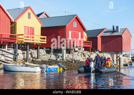 Personnes dans un bateau gonflable au les hangars à bateaux sur la côte de la Norvège Banque D'Images