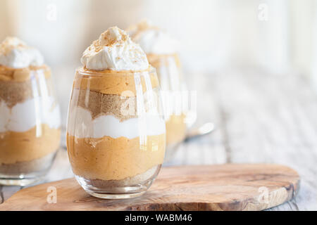 Citrouille dessert bagatelle maison faite de purée de potiron, crème de fromage, les miettes de biscuits et crème fouettée. Extreme focus sélectif avec brouillé backgroun Banque D'Images