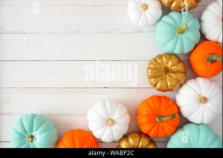 Coin automne frontière de diverses citrouilles coloré sur un fond de bois blanc. Vue de dessus avec l'exemplaire de l'espace. Banque D'Images