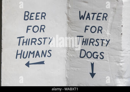 L'homme assoiffé de bière, de l'eau pour les chiens assoiffés. Inscription peinte à la main sur un mur de pub à Cirencester, Cotswolds, Gloucestershire, Angleterre Banque D'Images