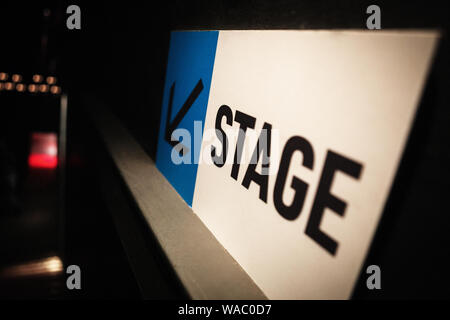 Stade signe pour performer dans night club sur backstage.conseil blanc et bleu avec la flèche indiquant le sens de l'entrée en scène de musique de divertissement.ev Banque D'Images