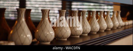 Vases en porcelaine vide sur l'étagère en bois avec volets de la réflexion dans le miroir Banque D'Images