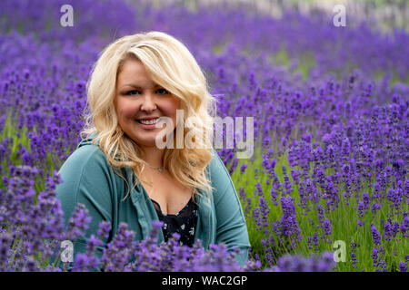 Blonde femme pose dans un champ de lavande dans une ferme de Sequim Washington pendant l'été, fête de la lavande à détendu Banque D'Images