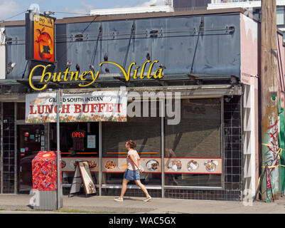 Femme marche passé le Chutney Villa South Indian restaurant sur East Broadway Street, à Mount Pleasant, Vancouver, BC, Canada Banque D'Images