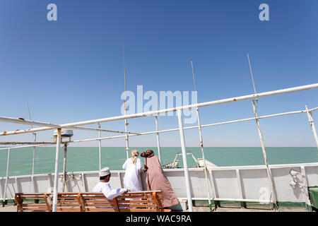 Les gens en costume traditionnel sur le pont du ferry boat à l'île de Masirah, Oman Banque D'Images