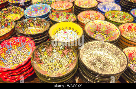 Plaques en céramique de différentes couleurs. Stand des plaques les unes sur les autres et sont peints avec des motifs lumineux de différentes formes. Banque D'Images