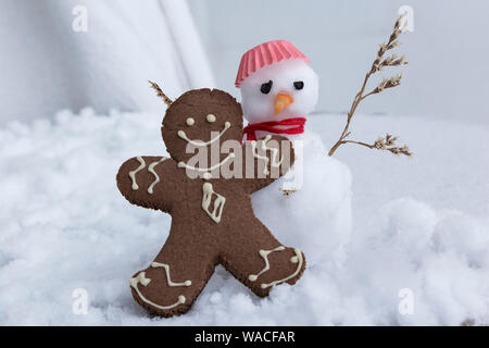 Gingerbread Man et bonhomme de neige dans la neige. Banque D'Images