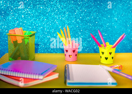 Matériel scolaire multicolores avec les portables de couleur et crayons dans des conteneurs Banque D'Images