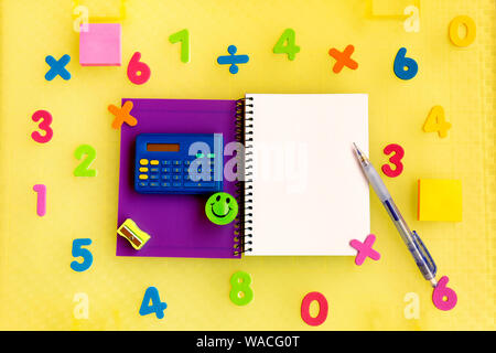 Arrière-plan avec blank notepad entouré par des chiffres et une multicolore calculatrice pour apprendre les mathématiques Banque D'Images