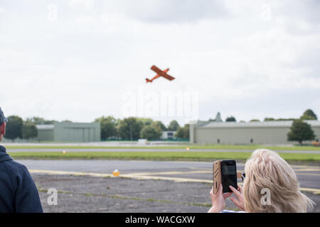 Une dame spectateur à airshow prendre des photos de performances sur téléphone mobile (usage éditorial uniquement) Banque D'Images