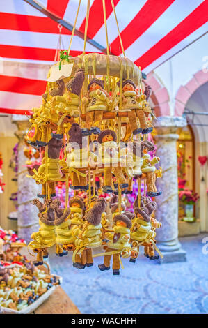 Les petits jouets dans des vêtements tricotés sur une balançoire à la piscine en plein air de fête boutique décorations de décrochage à Salzbourg, Autriche Banque D'Images