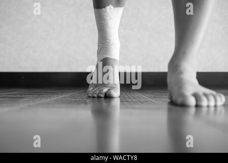 Version noir et blanc de la marche de l'athlète de l'avant avec une blessure à la cheville et travail sur bande Banque D'Images