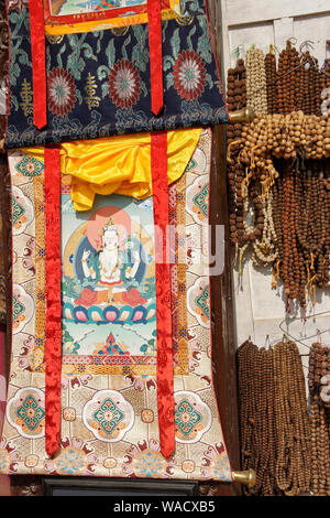 Thangkas bouddhistes tibétaines (tentures) et chapelet en vente en magasin à Boudhanath, Vallée de Katmandou, Népal Banque D'Images