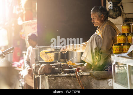 Un vieil homme indien Chapati cuisson dans les rues de Jaipur. Chapati est un pain plat sans levain. Banque D'Images