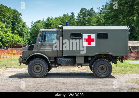 Han-sur-Lesse, Belgique - 25 juin 2019 : vert armée Belge camion ambulance avec croix rouge contre le feuillage vert et de ciel bleu. Banque D'Images
