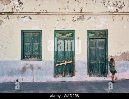 Vue latérale d'élégant woman leaning on wooden porte de maison délabrée à Tenerife sur la journée Banque D'Images